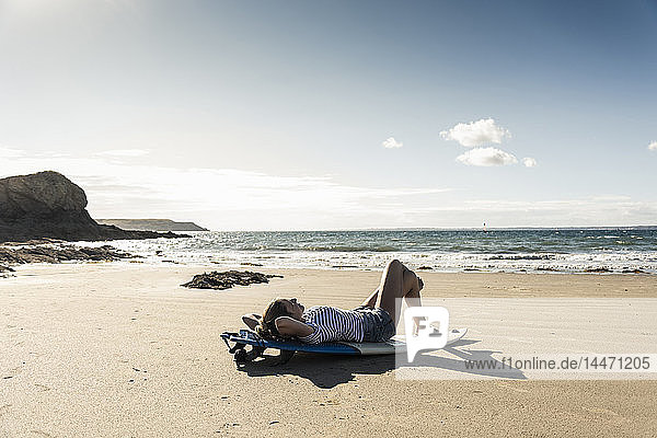 Junge Frau am Strand  Entspannung auf dem Surfbrett