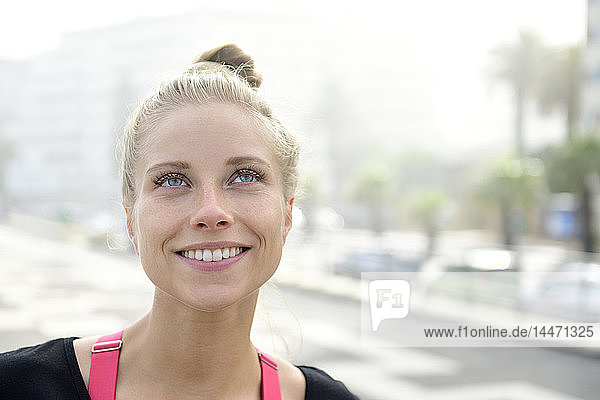 Porträt einer lächelnden blonden Frau im Freien