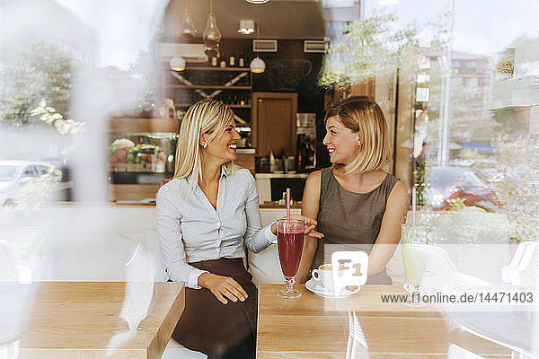 Two happy young women in a cafe