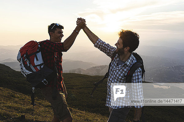 Italy  Monte Nerone  two happy and successful hikers in the mountains at sunset