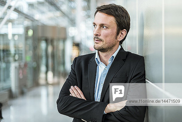 Businessman waiting at the airport with arms crossed