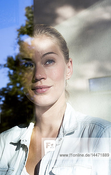 Portrait of smiling woman looking out of window