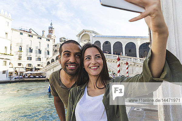 Italien  Venedig  ein Paar  das die Stadt genießt und ein Selfie mit der Rialto-Brücke im Hintergrund