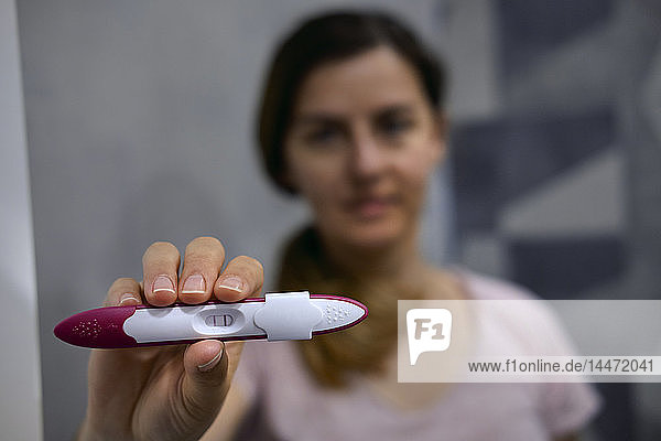 Woman showing positive pregnancy test