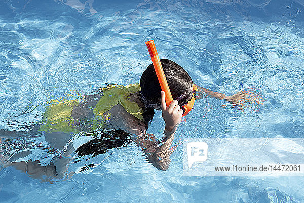 Kleines Mädchen mit Schnorchel und Taucherbrille im Schwimmbad