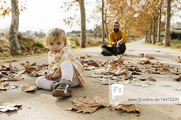 Vater und Tochter genießen im Herbst einen Vormittag im Park