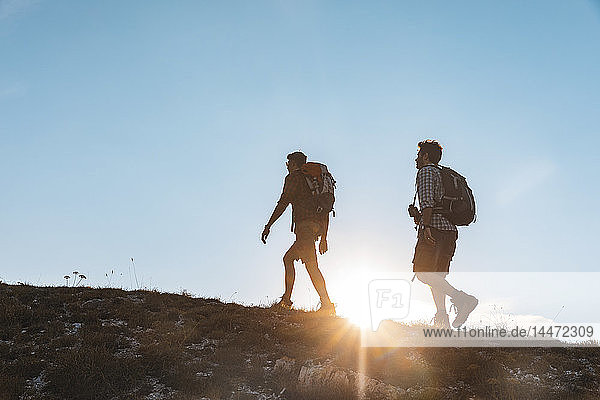 Italien  Monte Nerone  zwei Männer wandern in den Bergen bei Sonnenuntergang