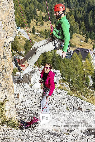 Italien  Cortina d'Ampezzo  Mann seilt sich mit Hilfe einer Frau in den Dolomiten ab
