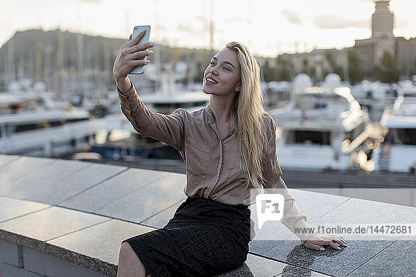 Smiling young woman taking a selfie at the waterfront