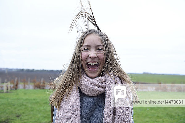 Porträt eines lachenden Mädchens mit wehendem Haar im Winter