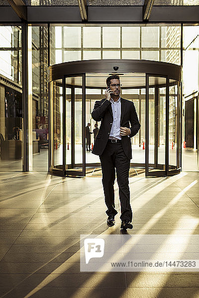 Businessman on cell phone in foyer of an office building