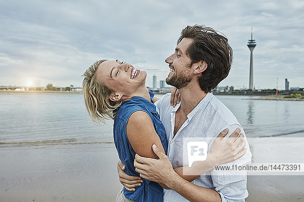 Deutschland  Düsseldorf  glückliches junges Paar am Rheinufer