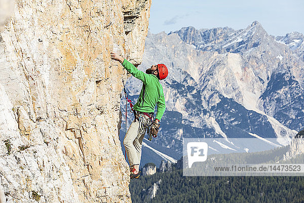 Italien  Cortina d'Ampezzo  Mann benutzt Kreidepulver beim Klettern in den Dolomiten
