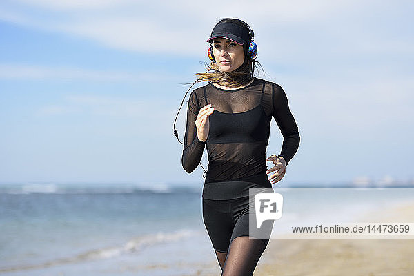 Sportliche Frau läuft am Strand
