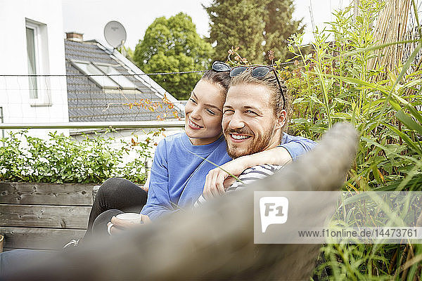 Young couple relaxing on their balcony  sitting on couch