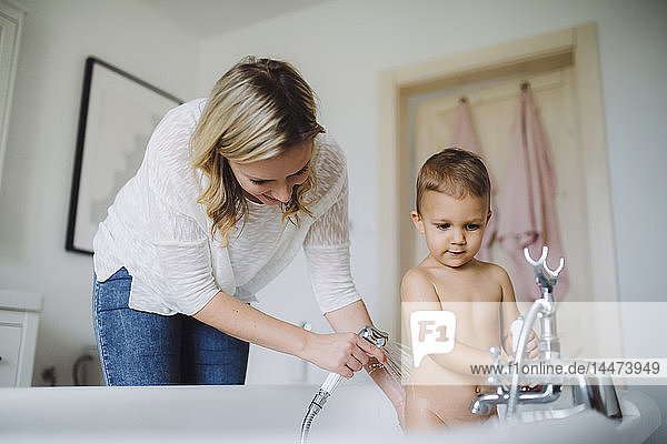 Mutter wäscht Kleinkind-Sohn zu Hause in der Badewanne