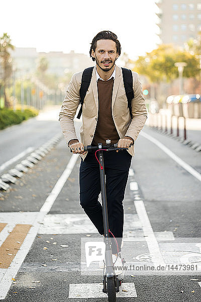 Porträt eines Mannes  der einen E-Scooter in der Stadt benutzt