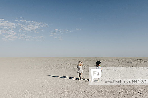 Two young women walking in the desert
