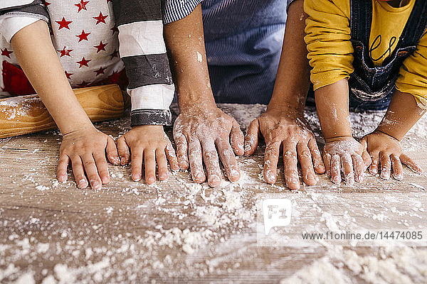 Mother and children with flour on their hands  partial view