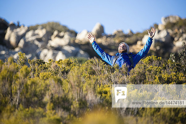 Spanien  Andalusien  Tarifa  glücklicher Mann auf einer Wanderung in den Bergen jubelt