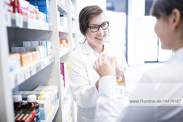 Pharmacist advising customer in pharmacy