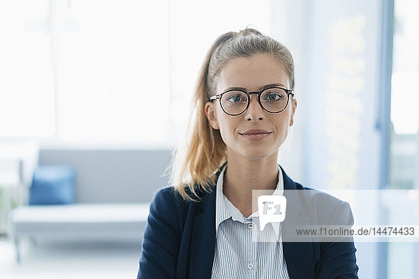 Porträt einer selbstbewussten jungen Geschäftsfrau  im Amt stehend