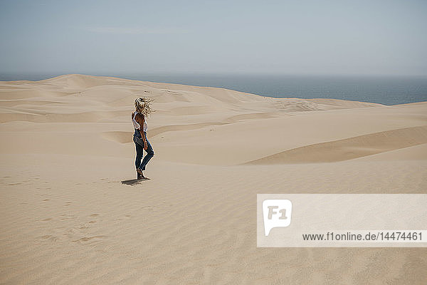 Namibia  Walvis Bay  Namib-Naukluft-Nationalpark  Sandwich-Hafen  Frau wandert in Dünenlandschaft