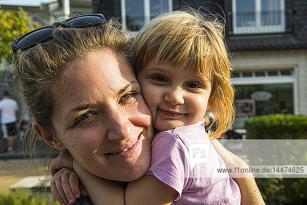 Deutschland  Rügen  Porträt der glücklichen Mutter und der kleinen Tochter Kopf an Kopf