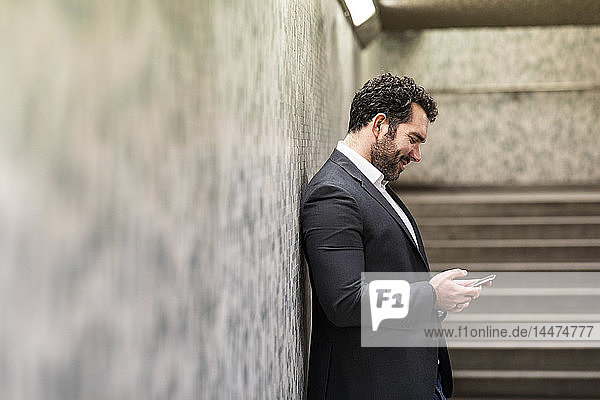 UK  London  businessman looking at his phone