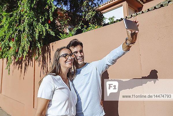 Glückliches Paar  das sich an einem sonnigen Tag ein Selfie gönnt