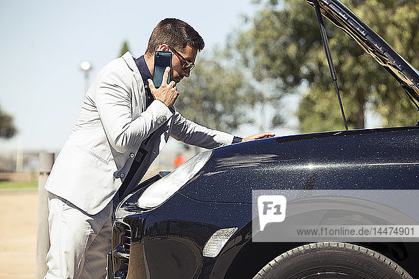 Young businessman having a car breakdown  talking on the phone