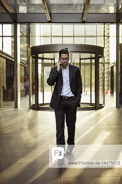 Businessman on cell phone in foyer of an office building
