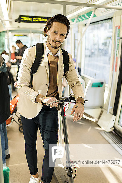 Porträt eines Mannes mit Rucksack und E-Scooter in der Strassenbahn