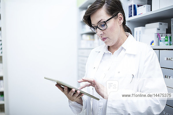 Pharmacist using tablet in pharmacy