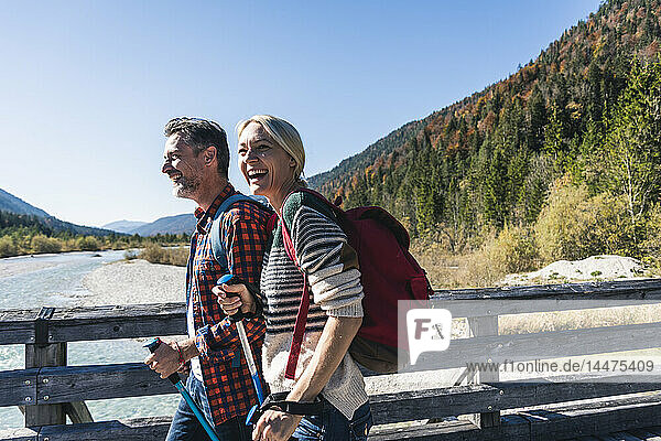 Österreich  Alpen  glückliches Paar auf einer Wanderung über eine Brücke
