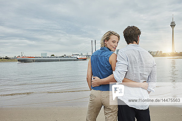 Germany  Duesseldorf  affectionate young couple at Rhine riverbank