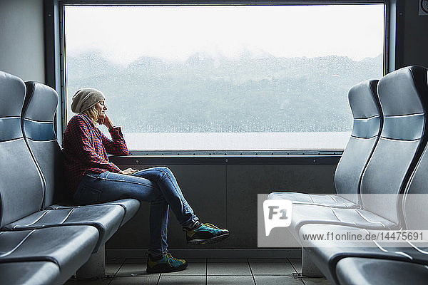 Chile  Hornopiren  Frau schläft am Fenster einer Fähre