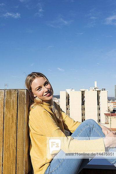 Junge Frau entspannt sich auf einer städtischen Dachterrasse