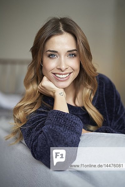 Portrait of smiling young woman on couch