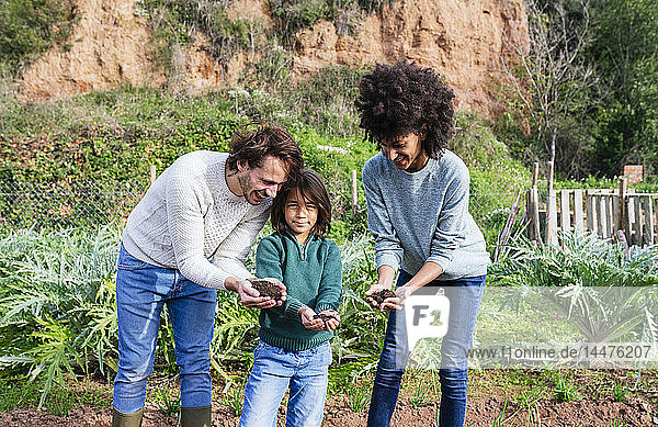 hapy family holding soil in their cupped hands