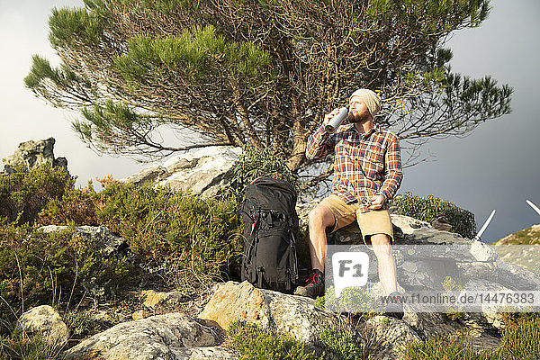 Spanien  Andalusien  Tarifa  Mann auf Wanderung  der eine Pause macht und aus der Flasche trinkt