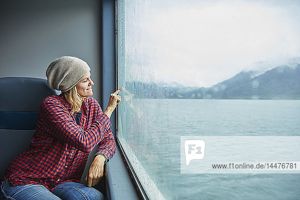 Chile  Hornopiren  Frau  die ein Herz auf das Fenster einer Fähre zeichnet