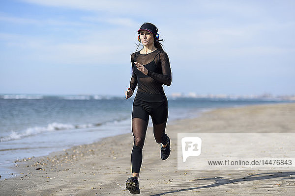 Sportliche Frau läuft am Strand