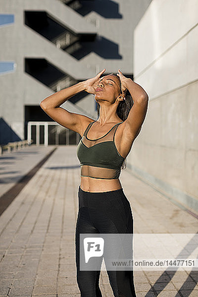 Sporty young woman having a break during workout in the city