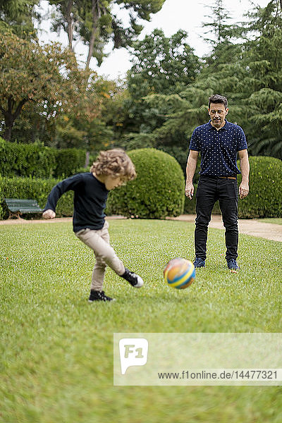 Vater und Sohn spielen im Park Fussball
