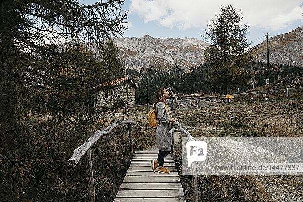 Schweiz  Engadin  Frau auf einer Wanderung auf einer Holzbrücke