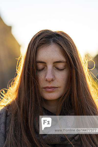 Porträt einer sommersprossigen jungen Frau mit Nasenpiercing im Herbst