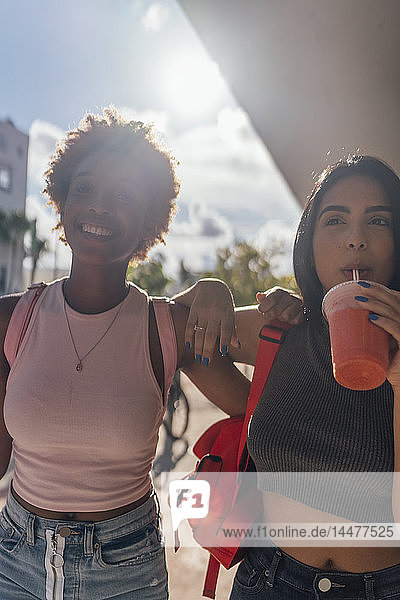 USA  Florida  Miami Beach  zwei glückliche Freundinnen bei einem Erfrischungsgetränk in der Stadt