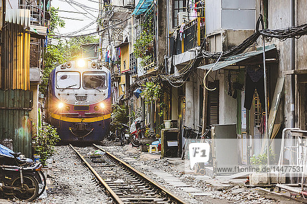 Vietnam  Hanoi  Blick auf eine Eisenbahn  die die Stadt durchquert und ganz in der Nähe von Häusern vorbeifährt