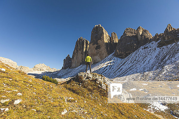 Italien  Tre Cime di Lavaredo  Mann wandert und steht vor den majestätischen drei Gipfeln